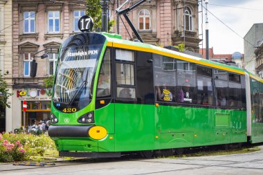 Poznan, Polonya - 07 Eylül 2025: Poznan şehir merkezindeki yeşil ve sarı tramvay modernlerine bakın. Büyük şehirde verimli, ekolojik, modern toplu taşıma