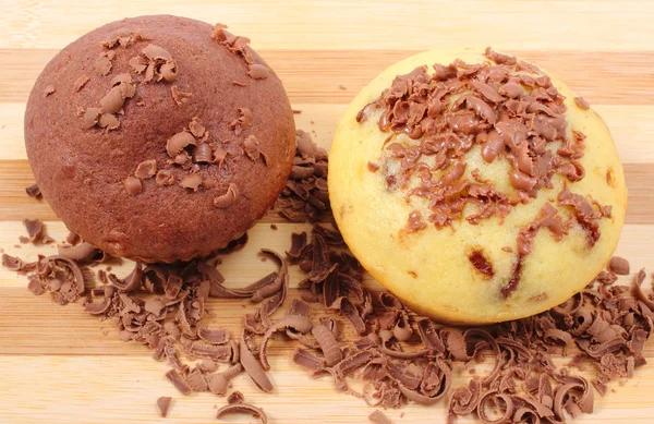 Fresh baked muffins and grated chocolate on wooden cutting board — Stock Photo, Image