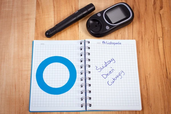 Dia mundial de diabete de inscrição polonês em caderno, círculo azul e glicosímetro, símbolo de diabético — Fotografia de Stock