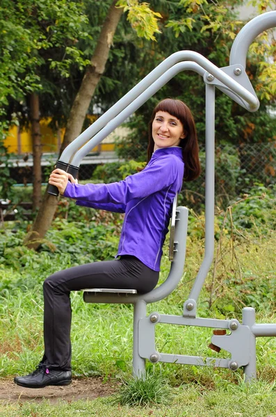 Woman exercising upper body on outdoor gym, healthy lifestyle — Stock Photo, Image