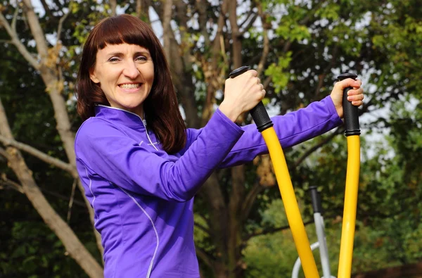 Woman exercising upper body on outdoor gym, healthy lifestyle — Stock Photo, Image