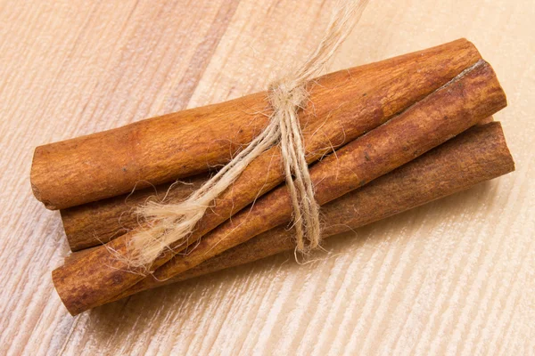Палички кориці на дерев'яному столі, приправа для приготування їжі — стокове фото