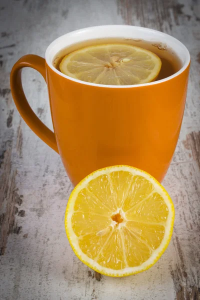 Citron frais et tasse de thé chaud sur une table en bois, une alimentation saine — Photo