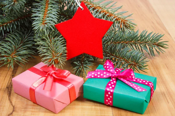 Гілки ялини з червоною дерев'яною зіркою та подарунки на Різдво — стокове фото