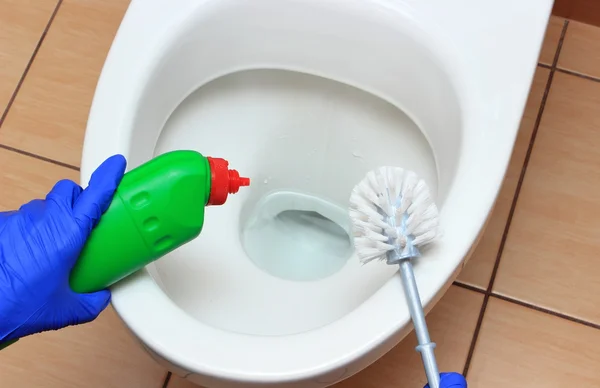 Hand einer Frau in blauem Handschuh reinigt Toilettenschüssel — Stockfoto