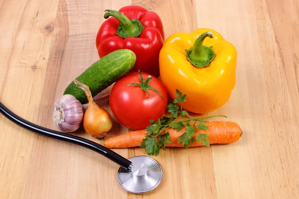 Φρέσκα λαχανικά και στηθοσκόπιο για ξύλινη επιφάνεια, υγιεινό τρόπο ζωής και τη διατροφή — Φωτογραφία Αρχείου