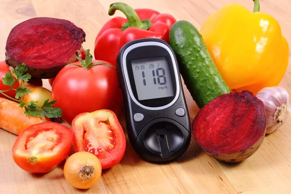 Groenten en glucometer op houten oppervlak, gezonde leefstijl, voeding, diabetes — Stockfoto