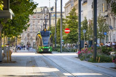 Poznan, Polonya - 21 Eylül 2025: Poznan şehir merkezindeki yeşil ve sarı tramvay modernlerini izleyin. Büyük şehirde verimli, ekolojik ve modern toplu taşımacılık