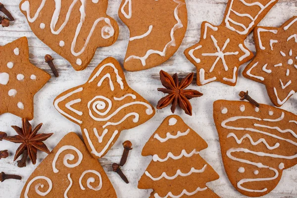 Nybakat dekorerade pepparkakor med kryddor på gamla trä bakgrund, juletid — Stockfoto