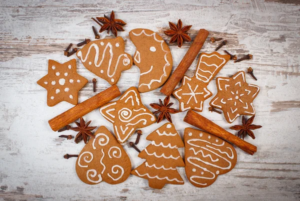 Pane di zenzero fresco decorato al forno con spezie su vecchio sfondo di legno, periodo natalizio — Foto Stock