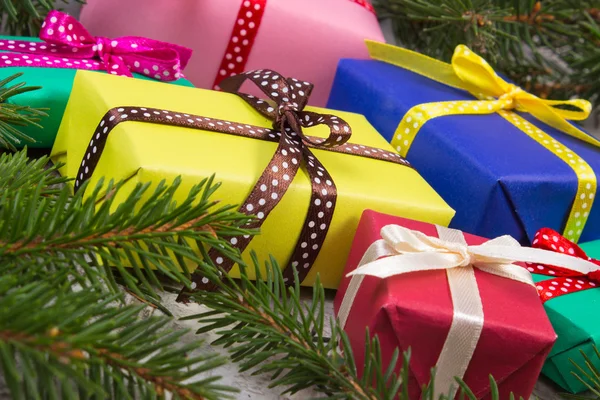 Ingepakte cadeaus voor Kerstmis of andere viering en vuren takken op oude plank — Stockfoto
