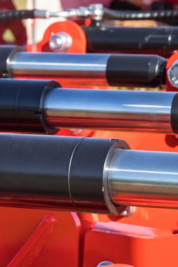 Kırmızı pnömatik ya da hidrolik makinede siyah pistonlar ya da aktivatörler. Teknoloji ve mühendislik