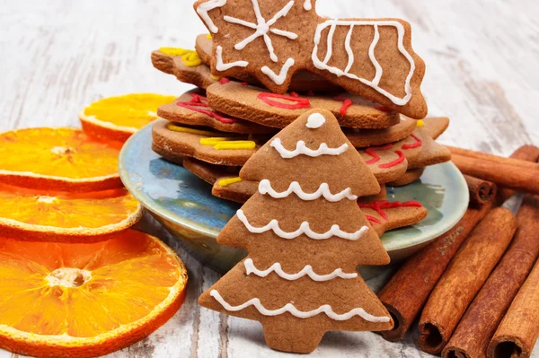 Decorated gingerbread with spices on old wooden background, christmas time — Stock Photo, Image