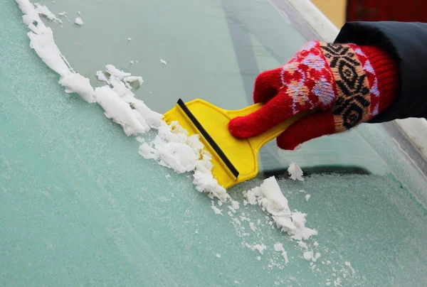 Hand der Frau kratzt Eis von Autoscheibe — Stockfoto