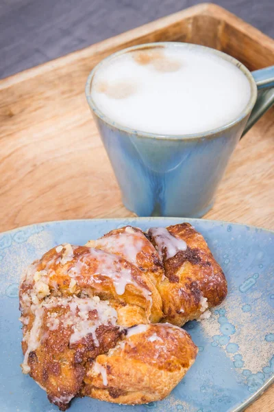 Açık mavi tabakta haşhaş tohumu ve bir fincan kahveyle birlikte taze pişmiş ciladan yapılmış hamur işi. Geleneksel Martin kruvasanları Polonyalı Poznan 'dan.