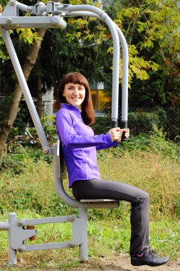 Açık spor salonu, sağlıklı bir yaşam tarzı üzerinde üst vücut egzersiz kadın