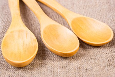 Wooden spoons on jute canvas, kitchen accessories
