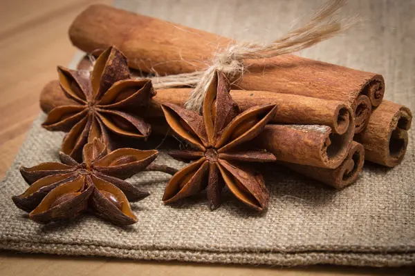 Palitos de anís estrellado y canela sobre mesa de madera, condimento para cocinar —  Fotos de Stock