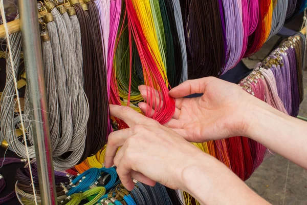 Hand einer Frau mit bunter Halskette am Stand auf dem Basar — Stockfoto