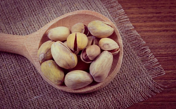 Vintage foto, pistache noten met lepel op houten tafel, gezond eten — Stockfoto