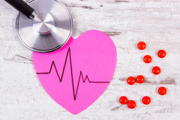 Srdce papíru s line kardiogram, stetoskop a doplnit prášky, medicíny a zdravotnictví koncepce — Stock fotografie