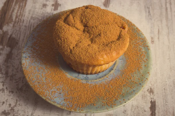 Foto vintage, Muffins frescos con canela en polvo sobre fondo de madera, delicioso postre —  Fotos de Stock