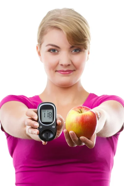 Mulher feliz segurando glicosímetro e maçã fresca, medindo o nível de açúcar, conceito de diabetes — Fotografia de Stock