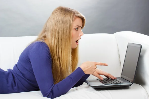 Verrast vrouw liggend op de Bank en tonen laptop, moderne technologie — Stockfoto