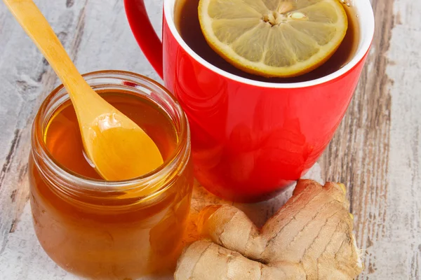 Honey, ginger and cup of tea with lemon on wooden table, healthy nutrition — Stock Photo, Image