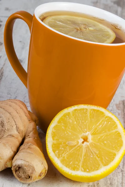 Свежий лимон, имбирь и чашка чая на деревянном столе, здоровое питание — стоковое фото