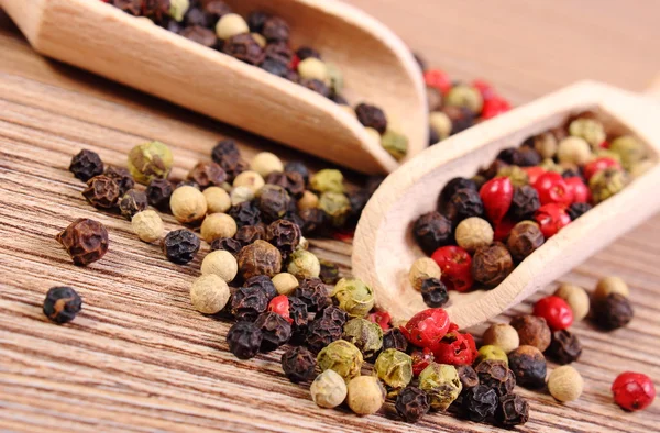 Verse gekleurde peper met lepel op houten achtergrond — Stockfoto