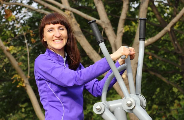 Woman exercising upper body on outdoor gym, healthy lifestyle — Stock Photo, Image