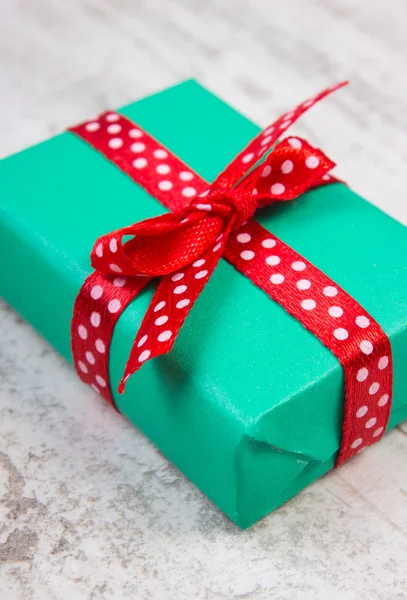 Presente verde para o Natal ou outra celebração na prancha de madeira — Fotografia de Stock