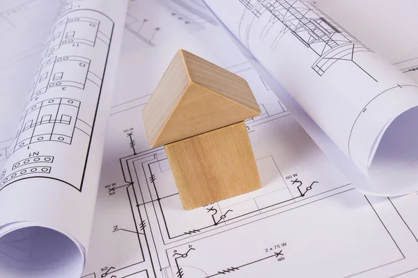 La casa de los bloques de madera y los rollos de los diagramas sobre la construcción el dibujo de la casa — Foto de Stock