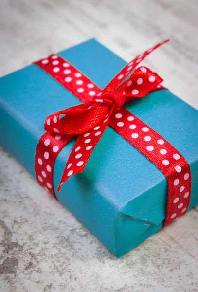 Presente azul para o Natal ou outra celebração na prancha de madeira — Fotografia de Stock