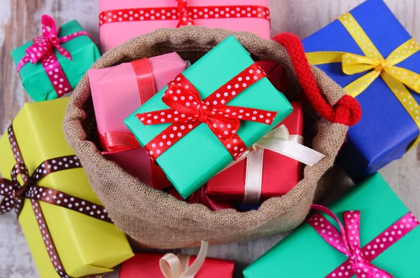 Heap of wrapped gifts for Christmas or other celebration on old wooden plank — Stock Photo, Image