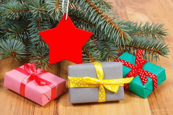 Гілки ялини з червоною дерев'яною зіркою та подарунки на Різдво — стокове фото