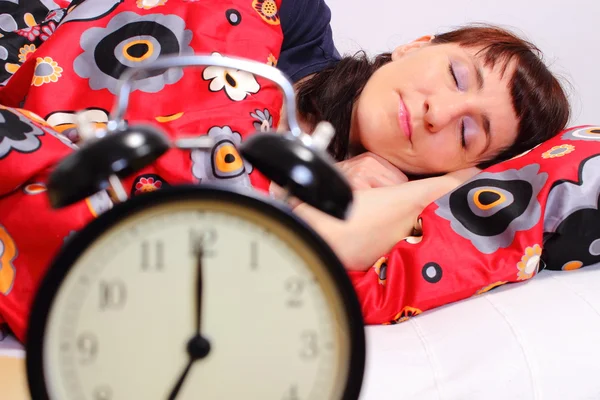 Brunette woman sleeping in her bedroom with alarm clock — Stock Photo, Image