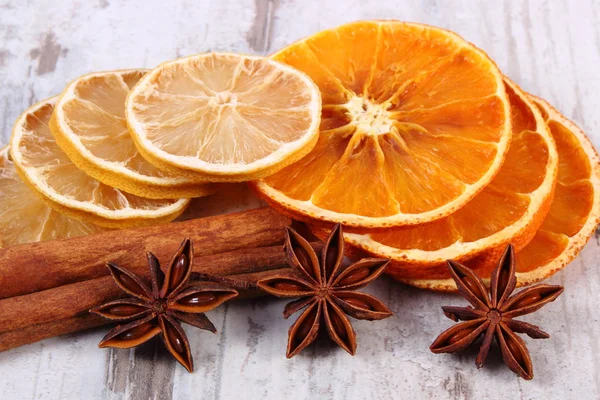 Segmenten van uitgedroogde citroen-, sinaasappel- en specerijen op oude houten achtergrond — Stockfoto