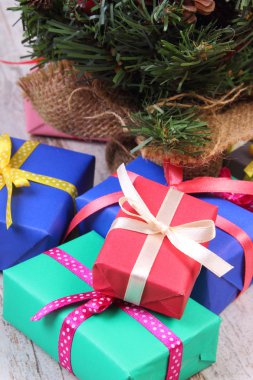 Noel ile yılbaşı ağacı eski beyaz tahta üzerinde kaydırılan renkli hediyeler