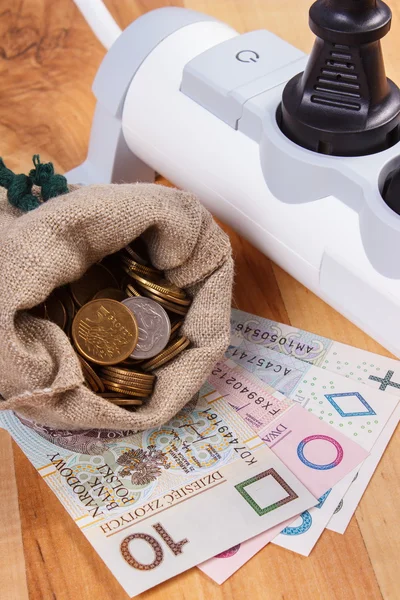 Tira de corriente eléctrica con enchufe conectado y dinero moneda polaco, costos de energía —  Fotos de Stock