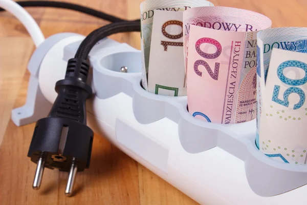 Rullar med polsk valuta pengar i elektriska grenuttag och frånkopplad plug, energikostnader — Stockfoto