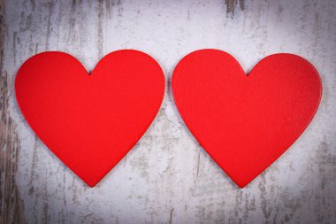 Valentine red hearts on old wooden white surface, symbol of love