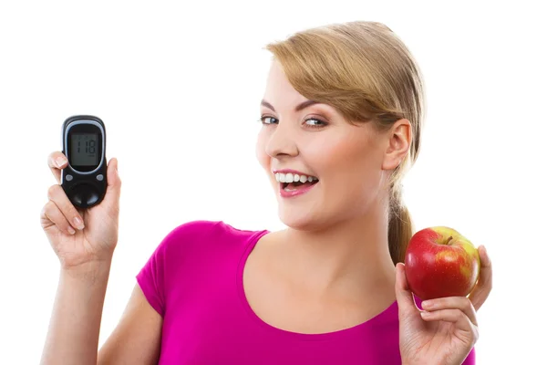 Mulher feliz segurando glicosímetro e maçã fresca, medindo e verificando o nível de açúcar, conceito de diabetes — Fotografia de Stock