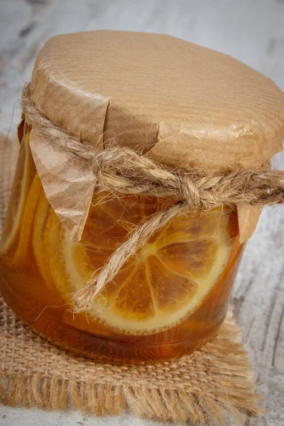 Citron au miel dans un bocal en verre sur une table en bois, une alimentation saine — Photo