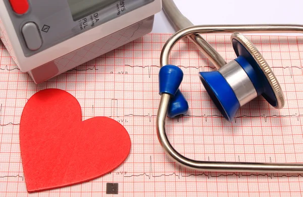 Stethoscope, heart shape, blood pressure monitor on electrocardiogram — Stock Photo, Image