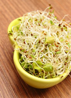 Ahşap masa üzerinde yonca ve turp lahanası ile kase