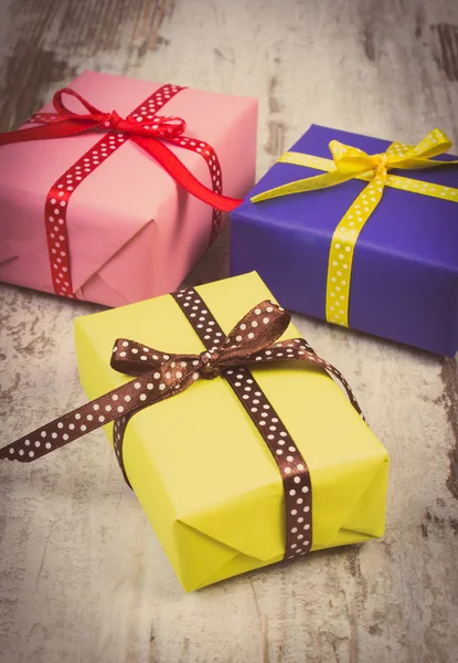 Vintage photo, Wrapped colorful gifts for Christmas or other celebration on old white plank — Stockfoto