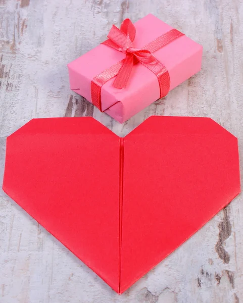 Regalo envuelto para cumpleaños, San Valentín u otra celebración y corazón rojo — Foto de Stock