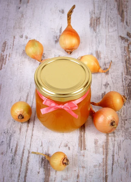 Свежий органический мед в стеклянной банке и лук на деревянном фоне, здоровое питание и укрепление иммунитета — стоковое фото